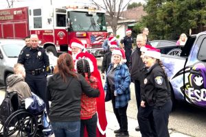 Along with Santa and Mrs. Clause, police officers and firefighters delivered piles of wrapped gifts to children for the holidays.