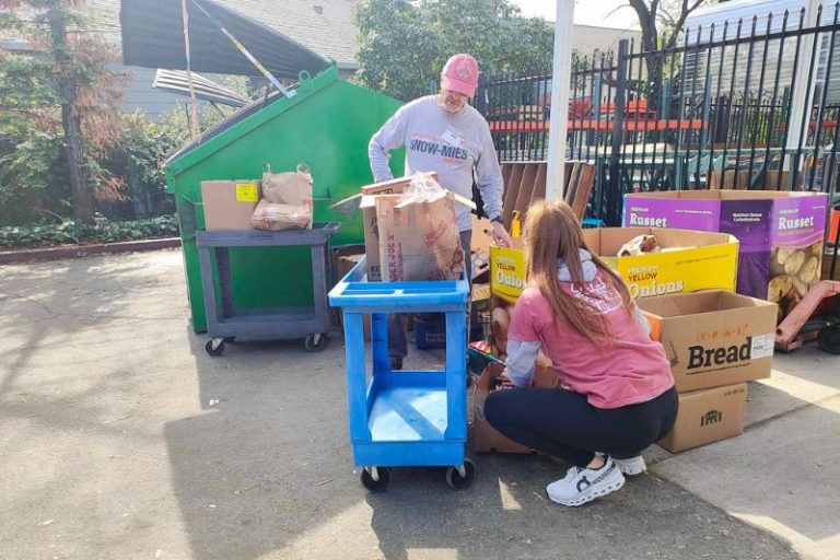 Dutch Bros Manager Stephanie Cotton helps load a bag of food at Sunrise Christian Food Ministry Tuesday, Feb. 11, 2025.